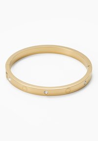 Bracelet jonc doré avec finition métallique lisse, doté de quatre cristaux transparents et d'un logo gravé sur sa surface.