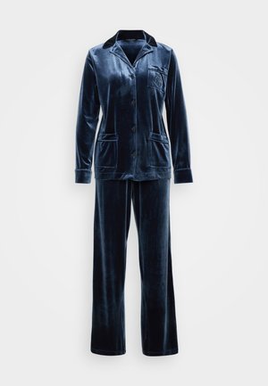 Marineblå fløyels pysjamassett med langermet skjorte med knapp og krage samt lomme, sammen med matchende bukser med vide ben.