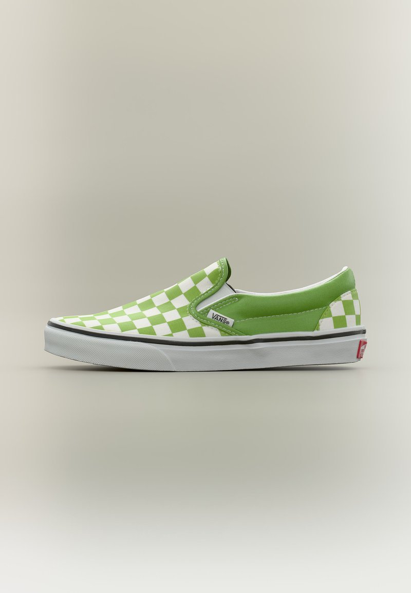 Πράσινο και άσπρο καρώ αθλητικό παπούτσι Vans slip-on με λευκή λαστιχένια σόλα και μαύρη ρίγα, ετικέτα λογότυπου στην πλευρά και κόκκινη ετικέτα στη φτέρνα.