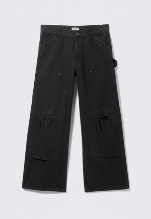 Pantaloni cargo neri in denim, caratterizzati da una vestibilità ampia, grandi tasche laterali e aree scucite nella parte anteriore vicino alle ginocchia.