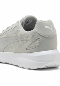Zapatillas deportivas de color gris claro, con material de malla y sintético, que presentan una superficie texturizada, un cuello acolchado y una suela de goma blanca. Logo de Puma en el talón.