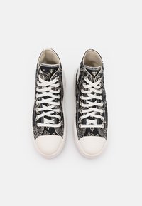 Czarne płócienne trampki z off-white sznurówkami i gumowym noskiem, z złotymi geometrycznymi wzorami i ilustracjami na wierzchnim materiale.