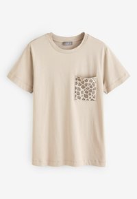 Beżowy bawełniany t-shirt z krótkimi rękawami, okrągłym dekoltem i kieszonką z ciemniejszym brązowym wzorem liści po lewej stronie z przodu.