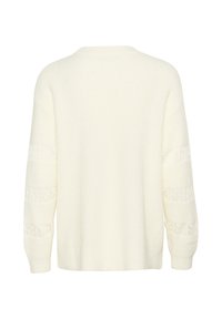 Cream knit sweater with a relaxed fit, featuring long sleeves and lace detailing on the sleeves. Soft texture and ribbed collar.