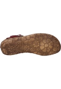 Bruine rubberen outsole met een gegraveerd bloemenpatroon, met grote en kleine bloemen. Soepele textuur met een brede, platte vorm.