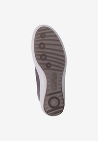 Podeszwa sneakersów z okrągłym i paskowym wzorem bieżnika w ciemnoszarym i białym kolorze, widok od dołu.