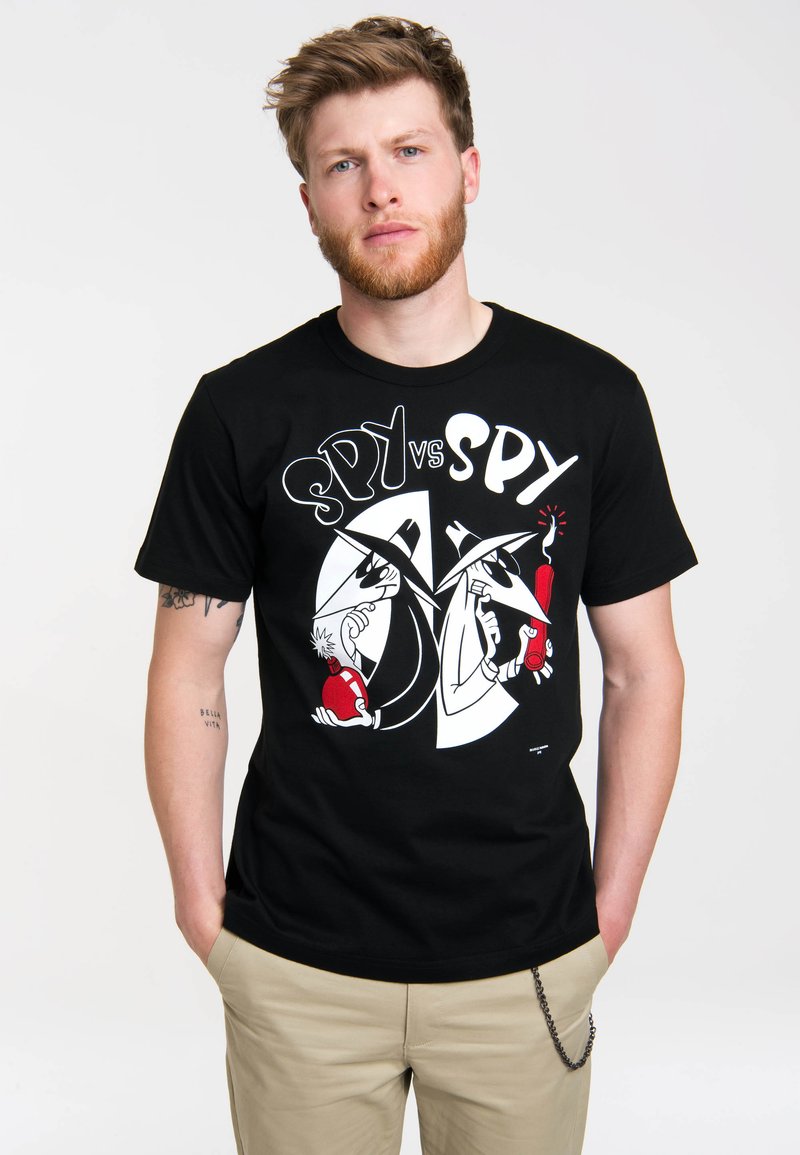 Black cotton t-shirt featuring a graphic print of two cartoon spies in black and white, with red accents, against a circular background.