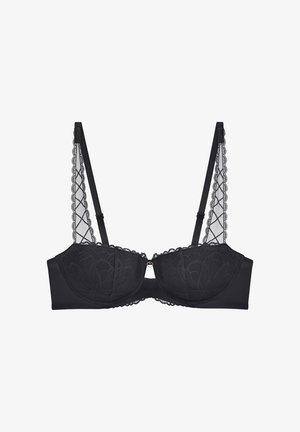 Svart bh med spetsöverdrag i blommönster, med byglar för stöd, och genomskinliga, vågiga axelremmar med ett hjärtformat spänne i mitten.