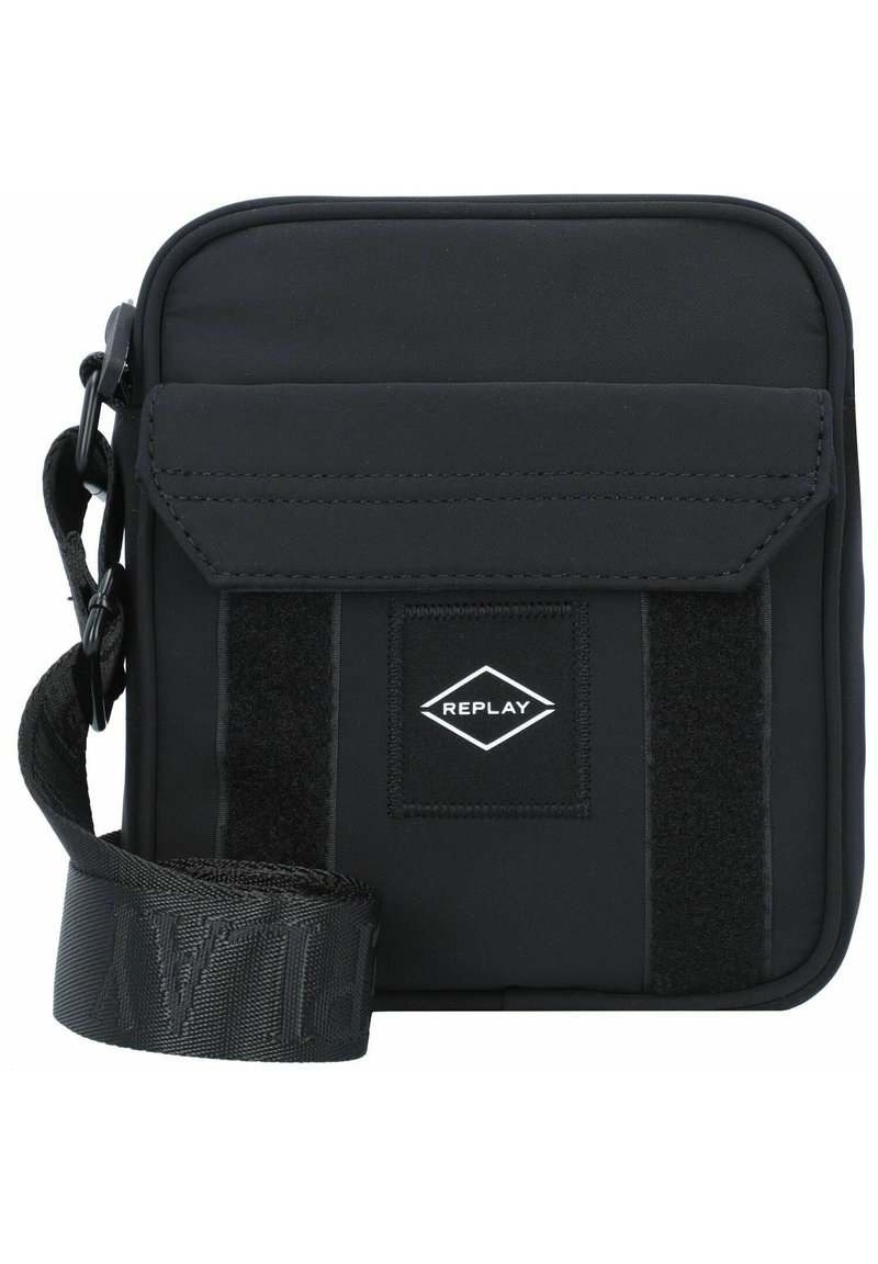 Schwarze Stoff-Crossbody-Tasche mit Klappenverschluss, Velcro-Akzent, verstellbarem Gurt und einem kleinen, rautenförmigen Logo-Patch.