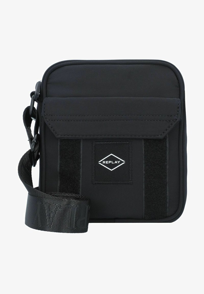 Schwarze Stoff-Crossbody-Tasche mit Klappenverschluss, Velcro-Akzent, verstellbarem Gurt und einem kleinen, rautenförmigen Logo-Patch.
