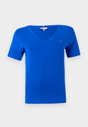 Kék V-nyakú póló, puha pamutból készült. Rövid ujjú, bal mellen kis logó található. Sima, egyenletes textúrájú.