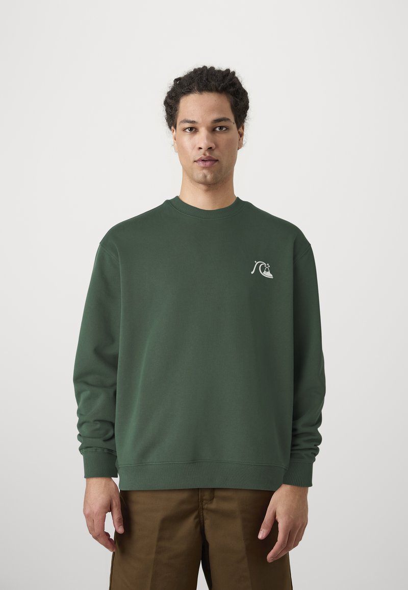 Sweatshirt vert en coton, avec un col rond et des poignets côtelés, arborant un petit motif graphique blanc sur la poitrine gauche.