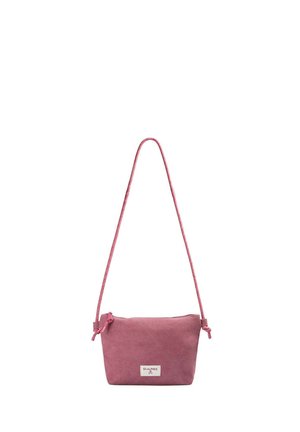 Pequeño bolso bandolera rectangular de ante rosa con una correa larga y fina y etiqueta de la marca Scalpers en el frente.