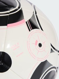 Weißer Fußball mit schwarzen und pinken geometrischen Designs, runde Form, genähte Panels und eine Textur, die auf ein synthetisches Material hinweist.