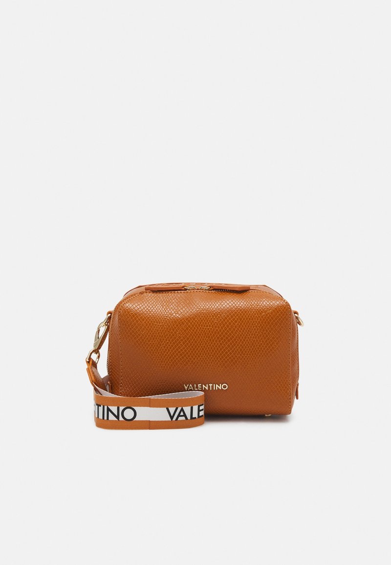 Orange texturerad läderväska med rektangulär form, guld blixtlås, och en märkesrem med svart och vitt tryck.