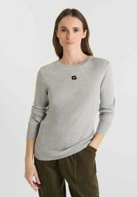 Grey knitted sweater with ribbed texture, round neckline, and black logo detail on the front. Features long sleeves and a slim fit.