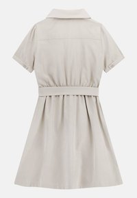 Sukienka z krótkim rękawem i kołnierzykiem w jasnobeżowym kolorze, z talią dopasowaną i rozkloszowanym dołem, zapinana na guziki przy mankietach, o gładkiej fakturze.