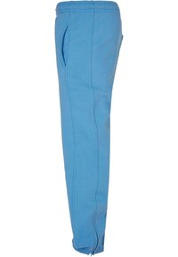 Blauwe katoenen joggingbroek met elastische tailleband, zijzakken en taps toelopende boorden. Soepele textuur met gestructureerde naden langs de benen.