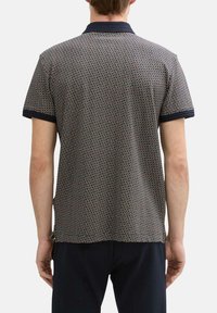 Polo shirt court à manches courtes, bleu marine et à motif, avec une finition texturée, un col et des manches contrastants, et un design tissé subtil.