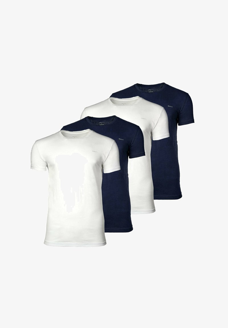 Quattro magliette semplici con scollo rotondo, in colori alternati bianco e blu navy, disposte in modo sfalsato.