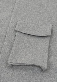 Grijze sweatshirtstof met een zachte textuur; heeft een gevouwen zakdetail aan de voorkant en een gladde, uniforme uitstraling.