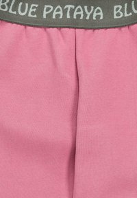 Rosa Baumwollshorts mit einem elastischen grauen Bund, auf dem der weiße Text "BLUE PATAYA" zu sehen ist. Weicher Stoff und lässiges Design.