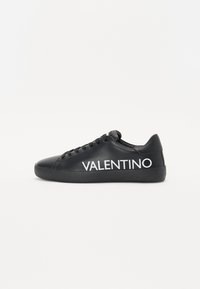 Fekete bőrsportcipő lekerekített orral, lapos fekete talppal és hangsúlyos fehér "VALENTINO" logóval az oldalon. Fűzős kialakítás hat szemlyukkal.