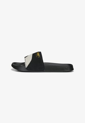 Zwarte en grijze schuifslipper met een gladde rubberen zool, bovenwerk van suede en gouden logodetails. Beschikt over een brede band die de wreef bedekt.
