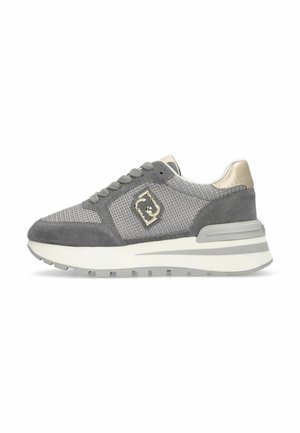 Baskets lacées grises et beige avec des détails en mesh et en suede, épaisse semelle blanche et emblème métallique sur le côté.