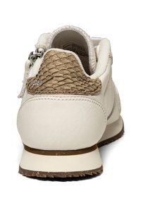 Baskets en cuir blanc avec un accent texturé marron au niveau du talon. Elles présentent une forme arrondie, un col rembourré et un détail de logo subtil.