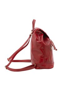 Sac à dos en cuir rouge avec un corps arrondi, des bretelles réglables, une poche zippée extérieure et un cordon de serrage en haut. Texture lisse.