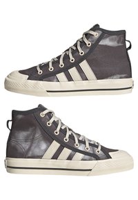 Vysoké tenisky z tmavě šedé plátno s světle šedými gumovými špičkami, třemi diagonálními pruhy a kontrastními černými akcenty na podrážce.