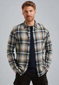 Camisa de cuadros en tonos beige, azul y naranja; presenta un cuello, mangas largas y una textura de tela con un ligero brillo.