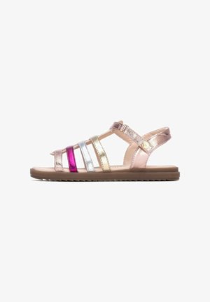 Sandalias de tiras con detalles metálicos en rosa, plata, oro y morado. Suela plana con superficie texturizada y correa ajustable en el tobillo.