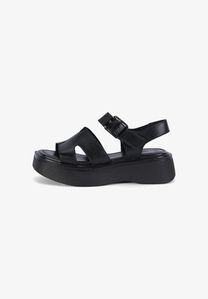 Sandale à plateforme en cuir noir avec semelle épaisse, bout ouvert, larges brides et bride de cheville réglable avec boucle.