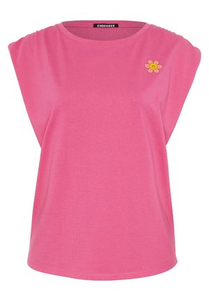 Pink sleeveless T-shirt featuring a round neckline and shoulder pleats. Includes a small embroidered smiling flower detail on the front.
