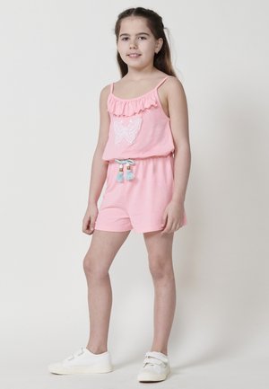 Rosa romper med rynket krave, prydet med en hvid sommerfugl broderi. Indeholder en snørelukning i taljen med farverige kvaster og beige sneakers.