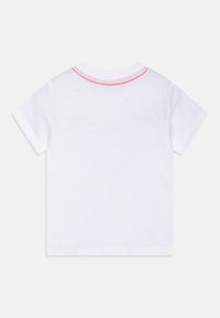 Weißes T-Shirt mit kurzen Ärmeln und einem runden Halsausschnitt, der pinke Nähte am Kragen hat. Weicher Baumwollstoff mit glatter Textur.