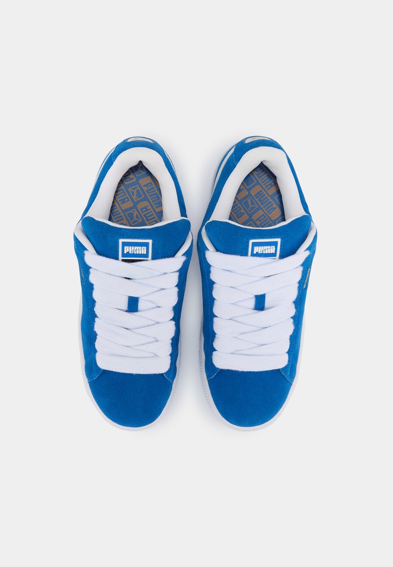 Baskets en suede bleu avec des lacets blancs, présentant un design classique et une semelle intérieure texturée avec un motif géométrique beige.