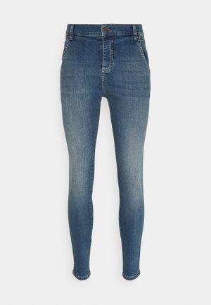 Jean skinny taille haute bleu avec poches avant, fermeture par bouton et détails délavés sur les cuisses et les genoux.