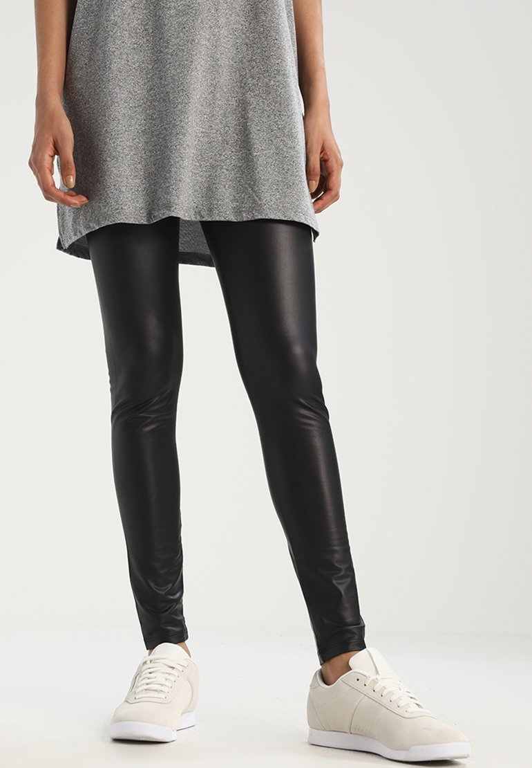 Leggings din piele sintetică negre, cu o croială strânsă și elegantă, asortate cu un top tunică gri și adidași de culoare deschisă. Textură fină, detalii minime.