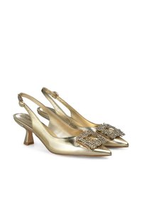 Zapatos de tacón slingback de satén dorado con punta afilada, una hebilla decorativa de strass y un tacón bajo tipo bloque. Textura suave con un acabado brillante.