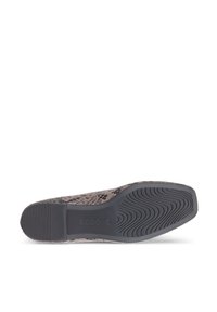 Semelle d'une chaussure plate à motif serpent avec une semelle en caoutchouc noir texturée et le logo de la marque ECCO embossé près du talon.