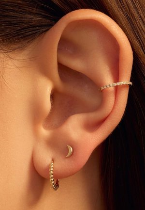 Gold hoop earring with bead details and a small crescent moon stud earring. Both are worn in the lobe, showcasing a smooth skin texture.