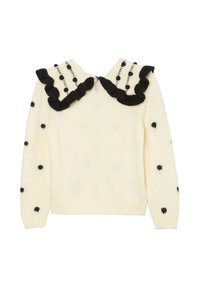 Crème gebreide trui met zwarte stippen en een brede, ruches zwarte-witte kraag met verticale stippenstrepen.