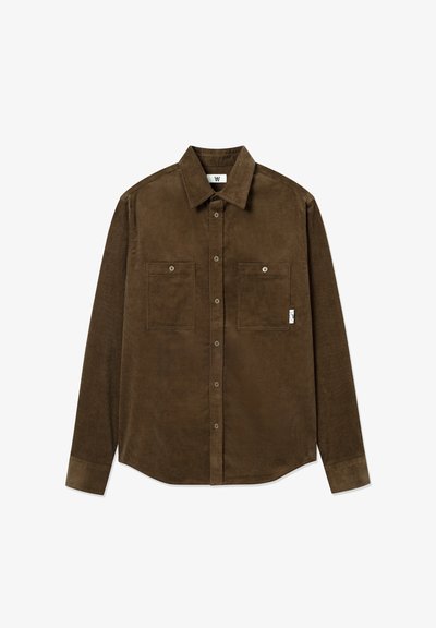 Brown corduroy shirt with long sleeves, two chest pockets, button-down front, and a slightly curved hem. Features subtle ribbed texture.