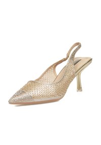 Zapato de tacón slingback beige con punta afilada, parte superior de malla, decorado con strass plateados y un tacón cuadrado transparente.