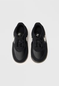 Sneaker Nike Force 1 neri con tomaia in pelle e tessuto texturizzati, logo Swoosh grigio, punta rotonda e chiusura con lacci.