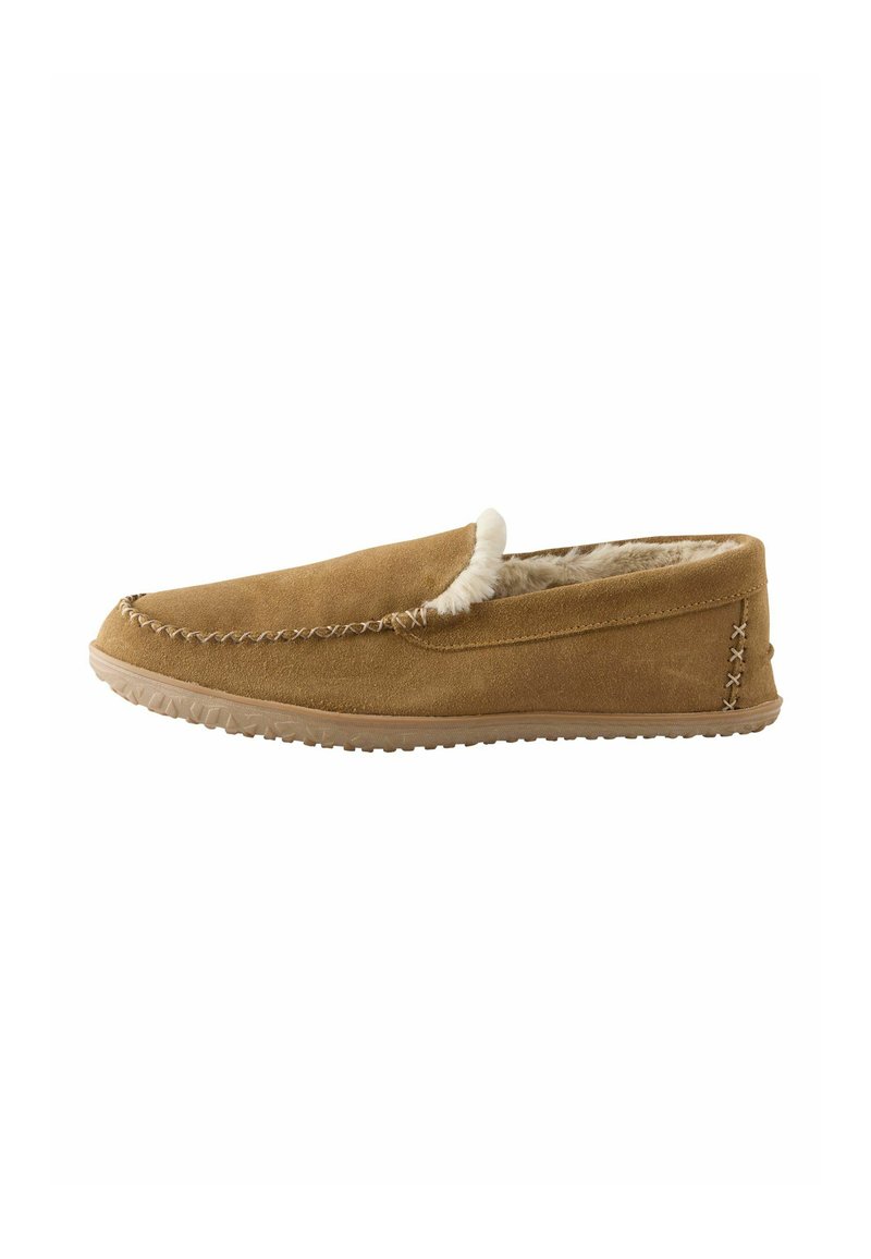 Tan suède instappers mocassins met een witte faux fur voering. Heeft stiksels langs de bovenkant en een getextureerde rubberen zool voor grip.