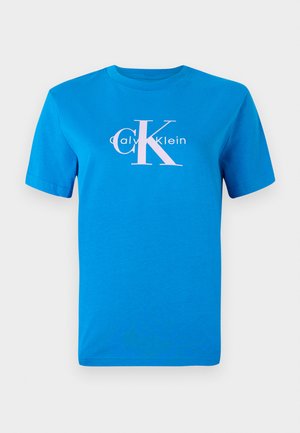 Camiseta de algodón azul con mangas cortas, que cuenta con un logo blanco de Calvin Klein y un gran gráfico rosa "CK" centrado en el frente.